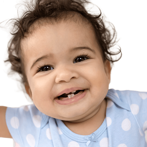 Smiling baby with curly hair and bright eyes, showing joy and curiosity.